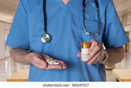 Senior male doctor with stethoscope in medical scrubs and holding bottle and tablets of generic white RX tablets to illustrate opioid epidemic