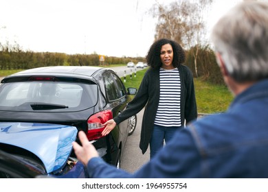 Senior male driver arguing over blame for car accident with a younger female motorist - Shutterstock ID 1964955754