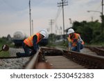 Senior male and female railway engineers are inspecting the railroad tracks for maintenance and improvements to ensure safe transportation of goods.