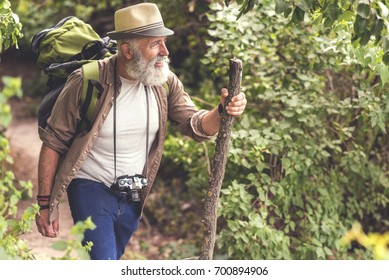 Senior male hiker walking with backpack in the wood - Powered by Shutterstock