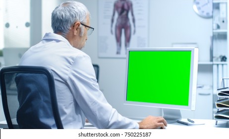 Senior Male Laboratory Researcher Working with Green Screen on His Personal Computer. Great for Mock up. - Powered by Shutterstock