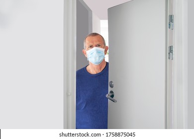 Senior male with medical face mask standing in doorway with half open door looking out at home or in a hospital. Hallway door and interior is white. Coronavirus, Covid-19 pandemic stay at home concept - Powered by Shutterstock