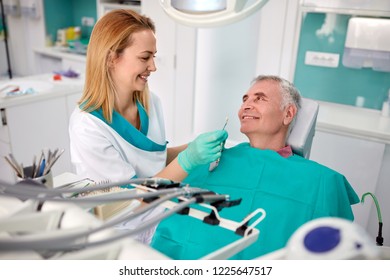 Senior Male Patient In Dental Chair With Nice Female Dentist