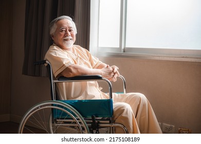 Senior Male Patient Sitting On Wheelchair In Hospital Smiling And Talking And Showing Something Outside The Window To Handsome Doctor In Labcoat In Room