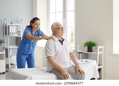 Senior male patient with spine problems and back pain sitting on examination bed in medical office while young female physiotherapist or chiropractor examines him. Physiotherapy treatment concept - Powered by Shutterstock