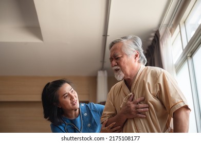 Senior Male Patient Wearing Gown Admitted In Hospital Holding Chest Due To Pain Suffering From Heart Attack While Holding And Taking Support Of Window In Ward And Private Room