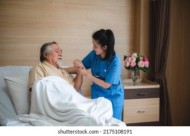 Senior Male Patient Wearing Gown Admitted In Hospital Holding Chest Due To Pain Suffering From Heart Attack While Holding And Taking Support Of Window In Ward And Private Room