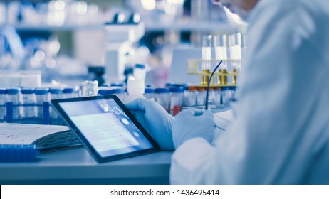 Senior Male Research Scientist is Using a Tablet Computer in a Modern High-Tech Laboratory. Genetics and Pharmaceutical Studies and Researches. - Powered by Shutterstock