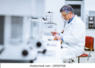 Senior Male Researcher Carrying Out Scientific Research In A Lab (shallow DOF; Color Toned Image)