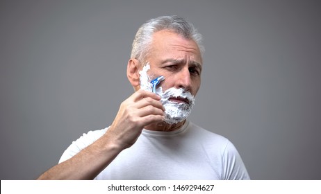 Senior male shaving, aging skincare cream, morning routine rituals, tradition - Powered by Shutterstock