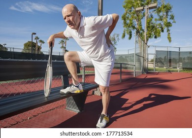 Senior Male Tennis Player With Back Pain On Court