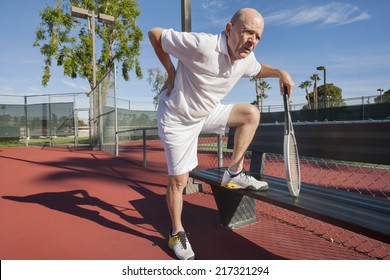 Senior Male Tennis Player With Back Pain On Court