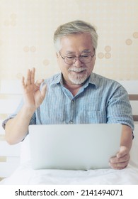 Senior Male Using A Laptop Computer Face Time Call To Relatives  Descendant Relatives Grandchild , Smiling Feel Happy In Bed At Home - Lifestyle Senior Concept