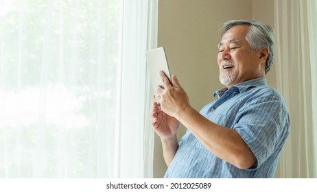 Senior Male using a smartphone , tablet computer , smiling feel happy in bedroom at home - lifestyle senior concept - Powered by Shutterstock