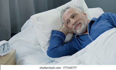 Senior male waking up and smiling after comfortable healthy sleep, health care - Powered by Shutterstock