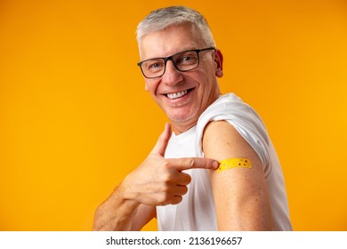 Senior man against yellow background recieved corona virus vaccination - Powered by Shutterstock