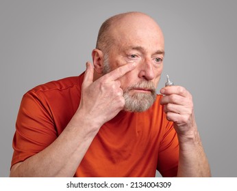 Senior Man Is Applying A Retinol Cream Under His Eyes, Skincare And Self Care For Men Concept