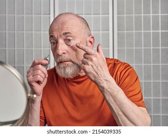 Senior Man Is Applying A Retinol Cream Under His Eyes, Skincare And Self Care For Men Concept