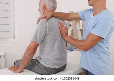 Senior Man With Back Pain. Chiropractic Pain Relief Therapy. Spine Physical Therapist And Paient.