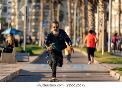 Senior Man With Beard Skateboard On The Street Of La Serena	