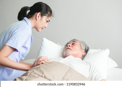 Senior Man In Bed Having Bed Dream With Nurse Come In And Calm Him Down. Old Asian Man And Beautiful Asian Nurse Woman In Bedroom. Senior Home Service Concept.