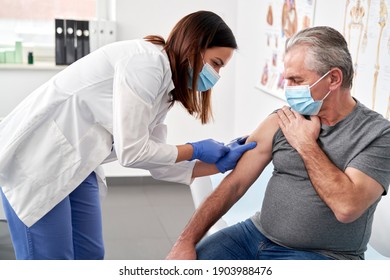 Senior man, der in einem Arztbüro geimpft wird                               