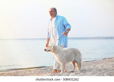 Senior man and big dog on riverside - Powered by Shutterstock
