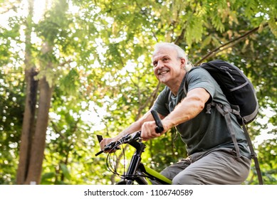 Senior man biking in the park - Shutterstock ID 1106740589
