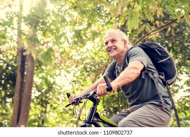Senior man biking in the park - Shutterstock ID 1109802737