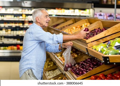 Senior man buying red onion at the grocery shop - Powered by Shutterstock