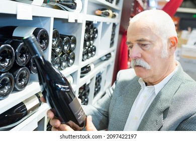 Senior Man Buying A Wine At The Grocery Store