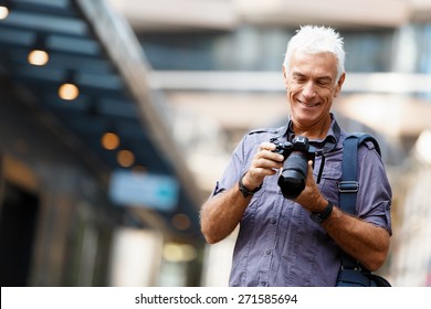 Senior man with camera in city - Powered by Shutterstock