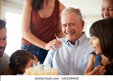 Senior man celebrating his birthday with family after blowing out candles on birthday cake, close up - Powered by Shutterstock