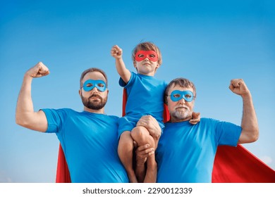 Senior, man and child outdoor against summer blue sky. Grandfather, father and son pretend to be superheroes. People having fun together. Family holiday concept. Happy Father's day - Powered by Shutterstock