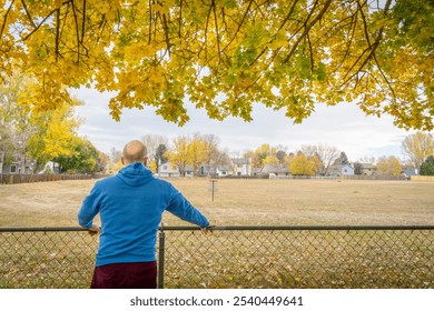 senior man contemplating fall landscape under maple tree in his backyard - Powered by Shutterstock