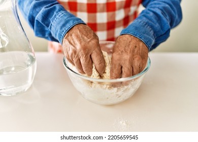 Senior Man Cooking Dough At Kitchen