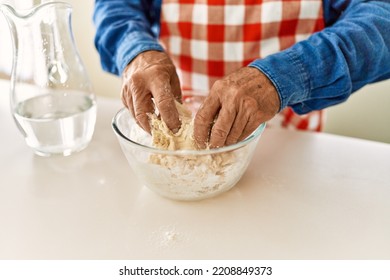 Senior Man Cooking Dough At Kitchen