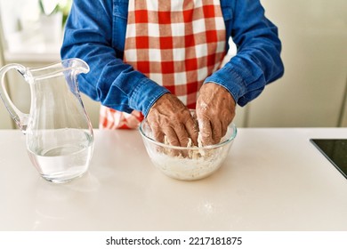 Senior Man Cooking Dough At Kitchen