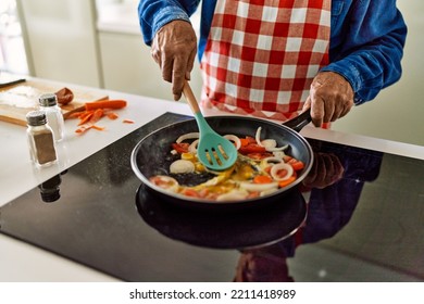 Senior Man Cooking At Kitchen