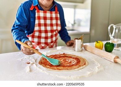 Senior Man Cooking Pizza At Kitchen