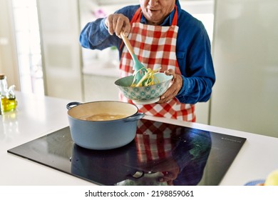 Senior Man Cooking Spaghetti At Kitchen