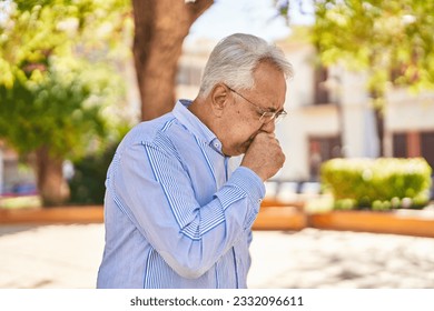 Senior man coughing at park - Powered by Shutterstock