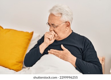 Senior man coughing sitting on bed at bedroom - Powered by Shutterstock