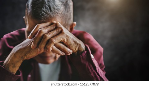 senior man covering his face with his hands. Depression and anxiety Copy space. in dark background