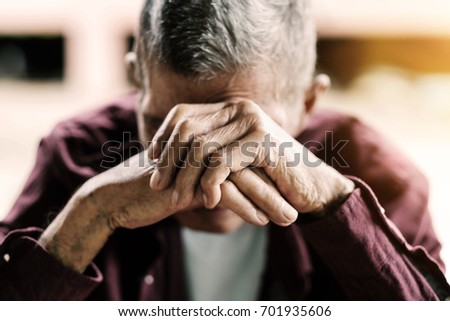 senior man covering his face with his hands.vintage tone