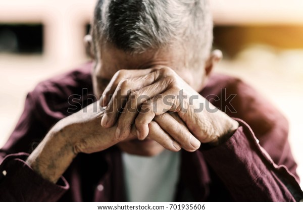 senior\
man covering his face with his hands.vintage\
tone