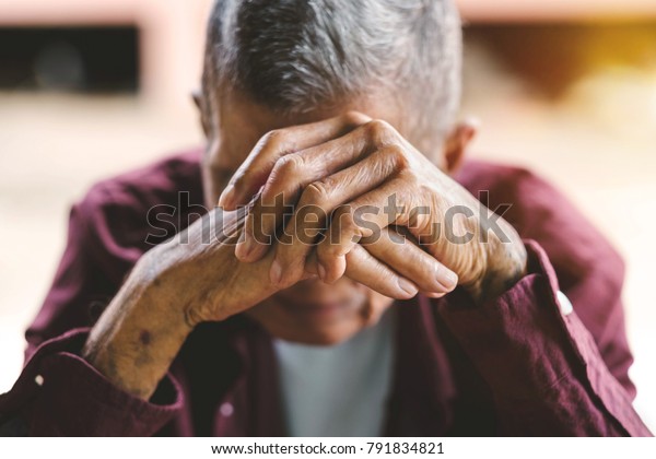 senior\
man covering his face with his hands.vintage\
tone