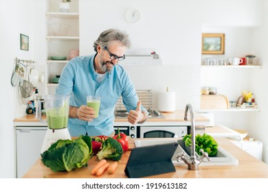 Senior man creating content for culinary blog, explaining the recipe step by step. Senior man using tablet for blogging - Powered by Shutterstock