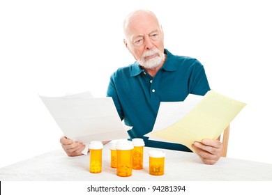 Senior Man Depressed By A Pile Of Medical Bills.  Isolated On White.