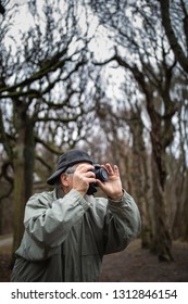 Senior man devoting time to his favorite hobby - photography - taking photos outdoor with his digital camera/DSLR